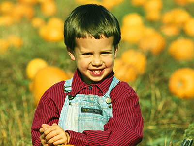 Child posing with pumpkins