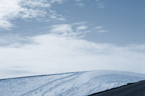 Snowy landscape with tire tracks